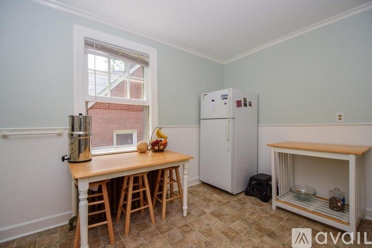 A kitchen with a table and a refrigerator.