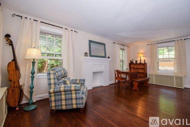 A living room with a chair, a couch, a table, and a fireplace.