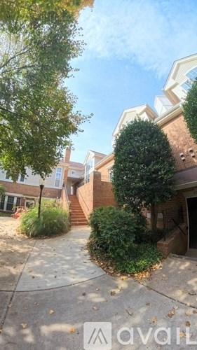 A tree in front of a building with a sign that says "avail".
