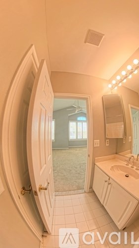 A bathroom with a sink, mirror, and a window.