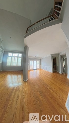 A wooden floor in a room with a spiral staircase.