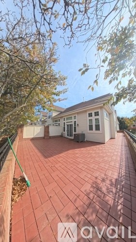 A house with a red tiled roof and a green rake on the left.