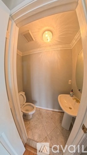 A small bathroom with a toilet, sink and light.