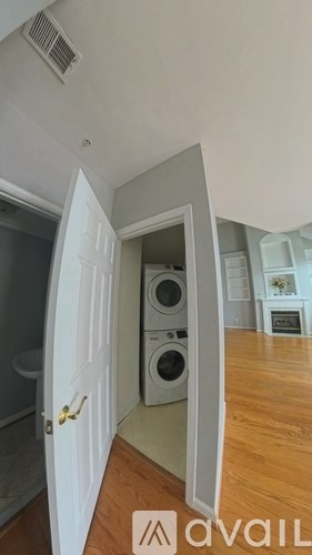 A white door is open to a room with a washing machine.