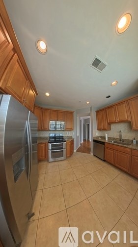 A kitchen with wooden cabinets and a refrigerator.