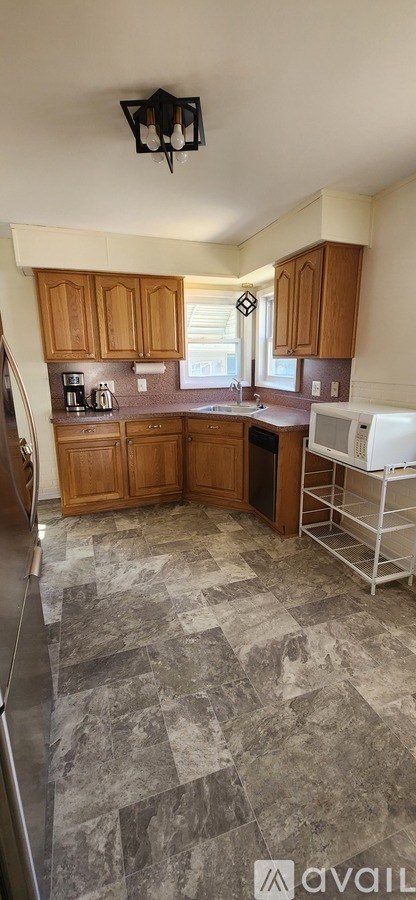 A kitchen with wooden cabinets and a tiled floor.
