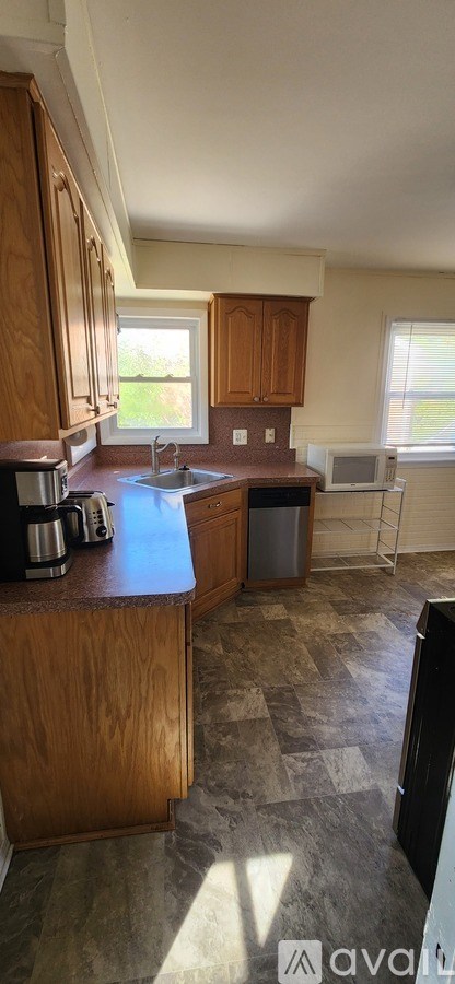 A kitchen with wooden cabinets and a tiled floor.
