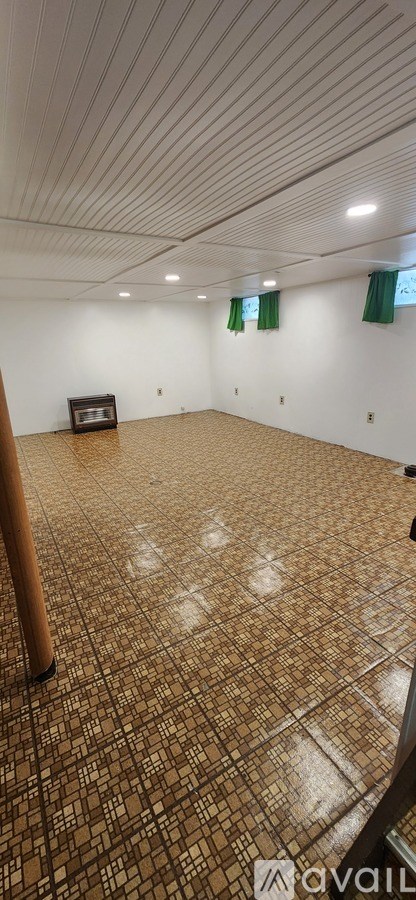 A room with a brown tiled floor and a white ceiling.
