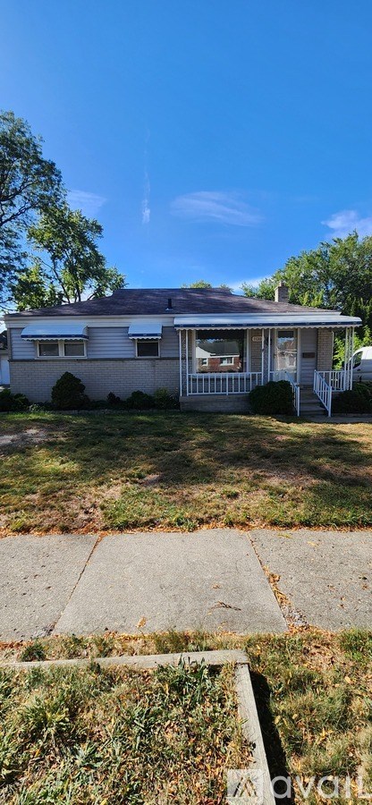 A house with a white fence and a green lawn.