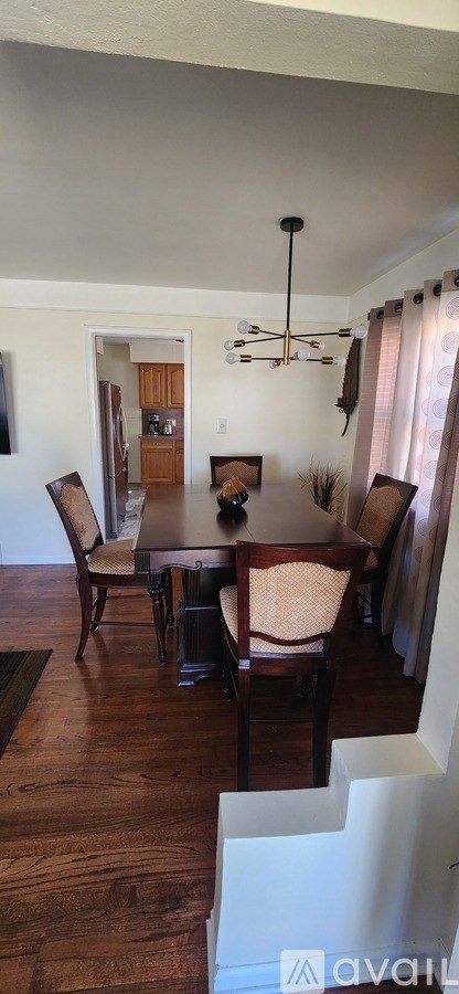 A dining room with a wooden table and chairs.