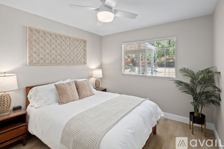 A bedroom with a large bed and a ceiling fan.