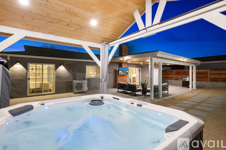 A hot tub is in the middle of a room with a wooden ceiling.