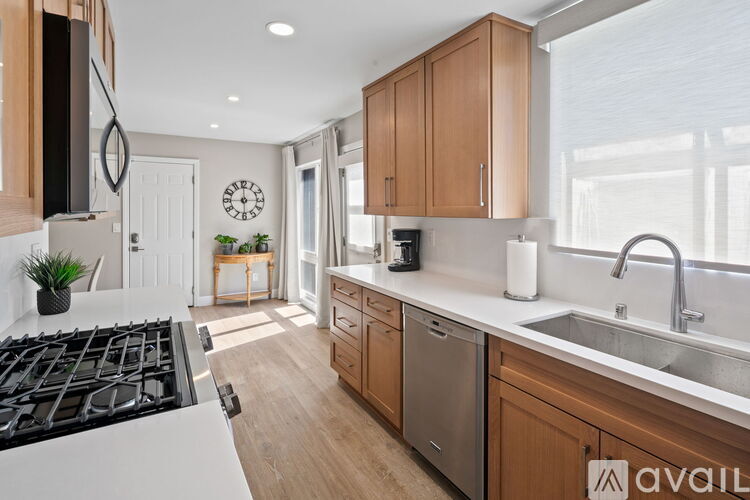 A kitchen with a white stove top and wooden cabinets.