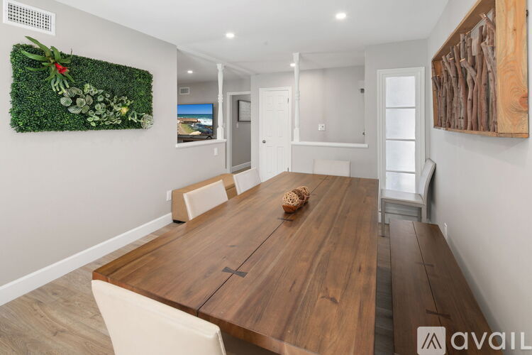 A modern dining room with a wooden table and chairs.