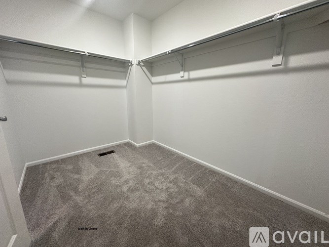 A walk in closet with a carpeted floor and white walls.