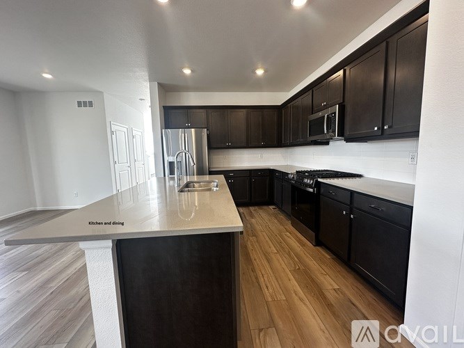 A modern kitchen with dark wood cabinets and a central island.