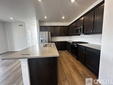 A modern kitchen with dark wood cabinets and a central island.