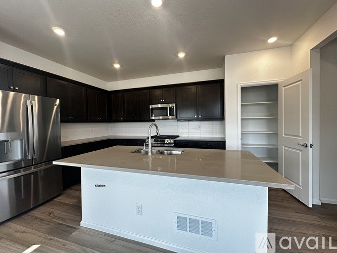 A kitchen with a white island in the middle.