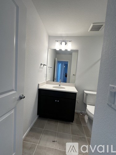 A bathroom with a sink, mirror, and toilet.