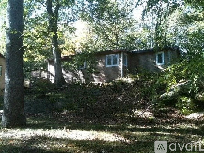 A house is surrounded by trees and bushes.