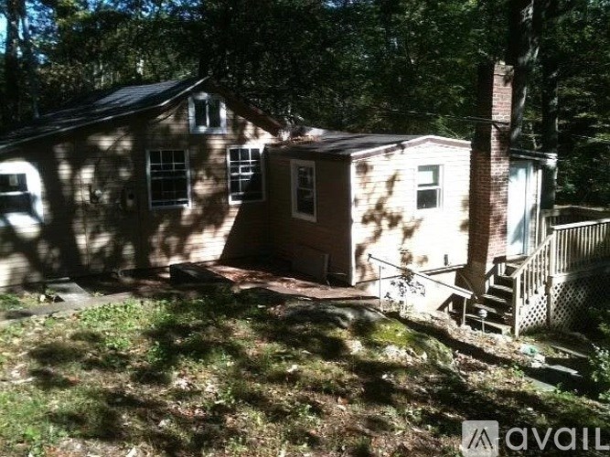 A house with a porch and a tree in front of it.