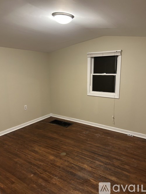 A room with a window and wooden flooring.