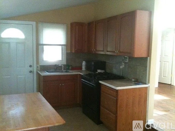 A kitchen with brown cabinets and a black stove top oven.