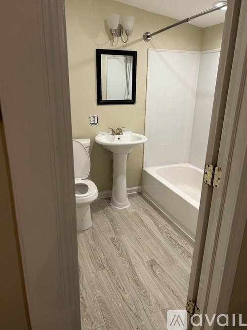 A bathroom with a toilet, sink, and bathtub.