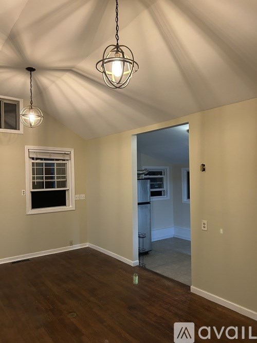 A room with a window and a chandelier hanging from the ceiling.