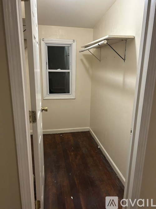 A small room with a wooden floor and a white door.