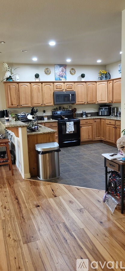 A kitchen with wooden cabinets and a black stove top oven.