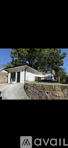 A house with a stone wall in front.