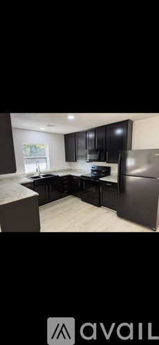 A kitchen with black cabinets and a white countertop.