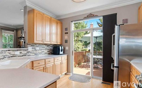 A kitchen with wooden cabinets and a black refrigerator.