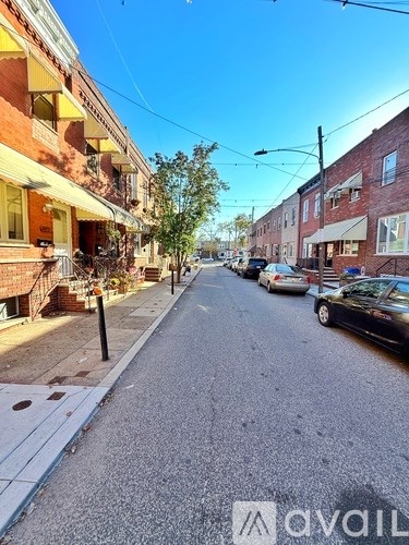 A street view of a residential area with cars parked on the side.