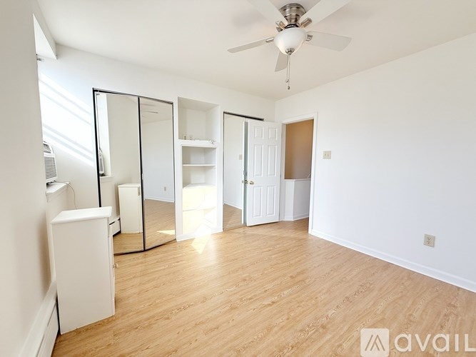 A room with a ceiling fan and a large mirror.