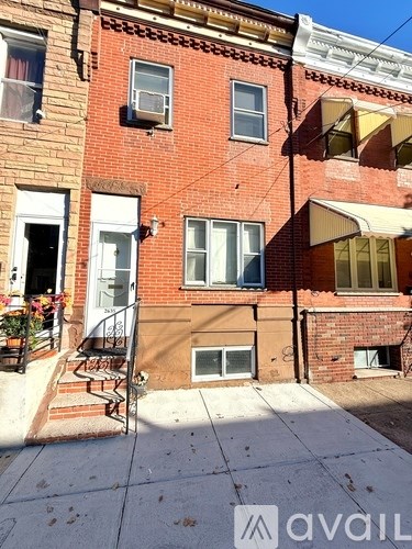 A red brick house with a white door and windows.