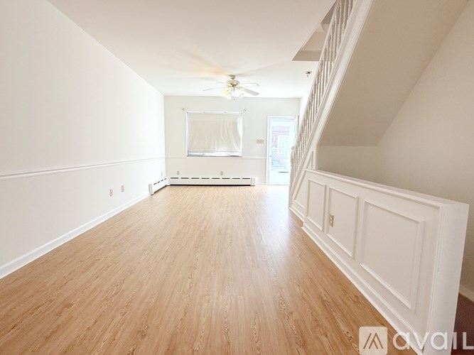 A room with wooden flooring and white walls.