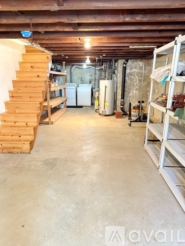A room with a staircase on the left and a refrigerator on the right.