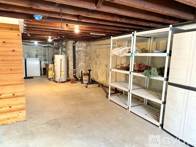 A room with a wooden wall and a white shelving unit.