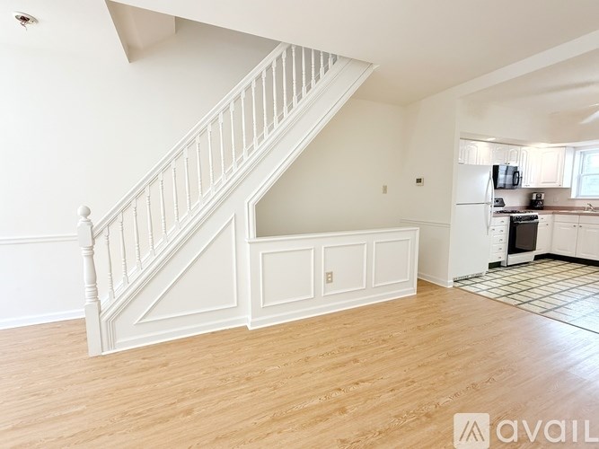 A spacious living room with a staircase leading to the upper floor.