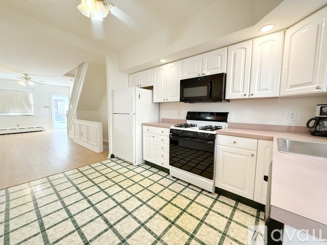 A kitchen with white cabinets and a black stove top oven.