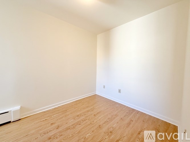 Empty room with wooden floor and white walls.