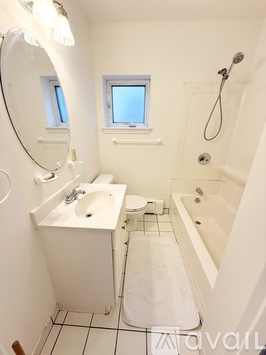 A small white bathroom with a sink, toilet, and bathtub.