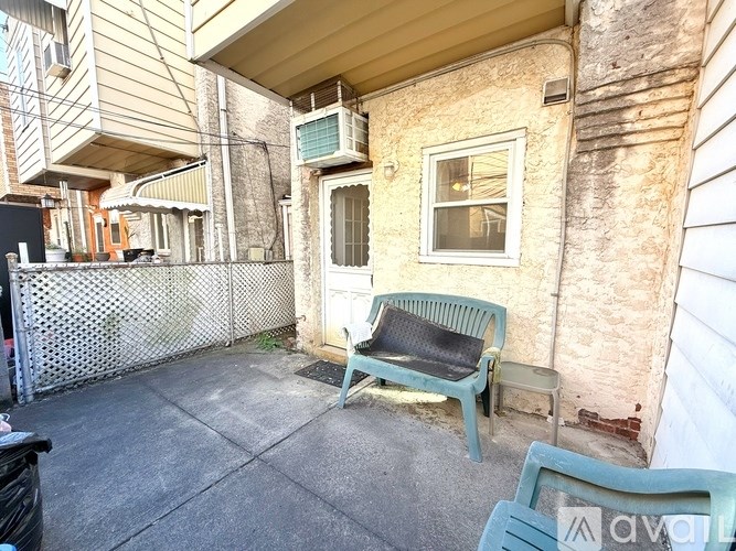 A patio with a chair and a table outside a house.