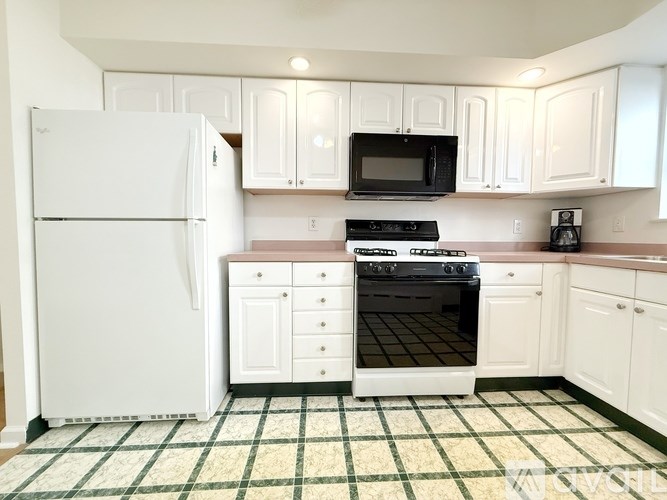 A kitchen with white appliances and cabinets.