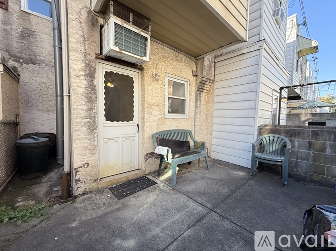 A small patio with a bench and a door.