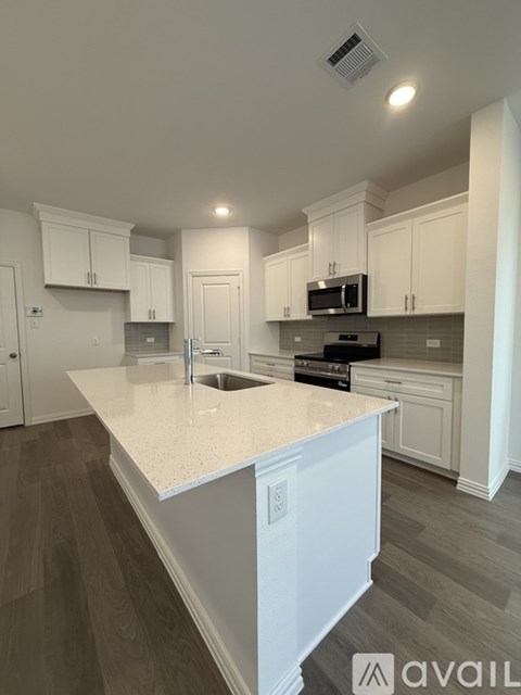 A kitchen with white cabinets and a countertop.