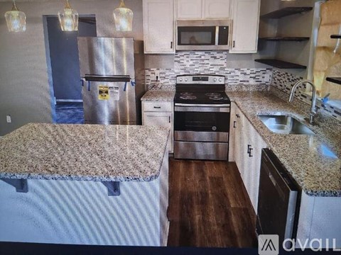 A kitchen with granite countertops and stainless steel appliances.