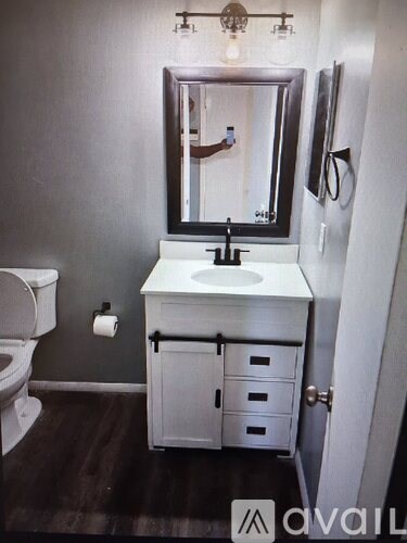 A bathroom with a white sink and a mirror.